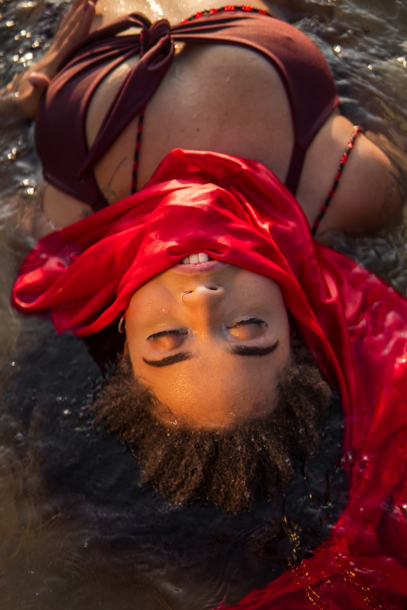 a woman in a red dress is floating in the water